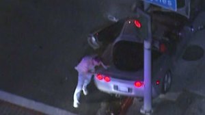 Police surrounded a silver Corvette in downtown Los Angeles after a lengthy pursuit. The driver was fatally shot when he exited the vehicle on Dec. 13, 2013. (Credit: KTLA)