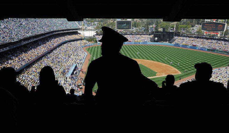 A Los Angeles Police Department officer looks at fans inside Dodger Stadium during the home opener against the Pittsburgh Pirates on April 10, 2012 in Los Angeles, California. Security was high at the stadium for the home opener after Bryan Stow was beaten into a coma in a Dodger Stadium parking lot following the home opener in March of 2011. (Credit: Kevork Djansezian/Getty Images)