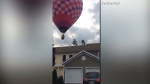 A hot air balloon is seen shortly before it crashed in a Massachusetts neighborhood on Saturday, July 19, 2014. (Credit: Jessica Pazi)