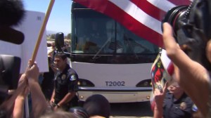 A bus filled with undocumented immigrants arriving in Murrieta was greeted by both news media and protesters on July 1, 2014. (Credit: KTLA)