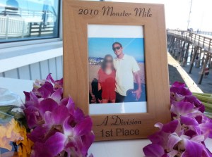 Flowers and photos were left in memory of Ben Carlson at the Newport Beach lifeguard station on July 7, 2014, a day after he died following a rescue. He is shown in a photo with an unidentified woman, whose face has been blurred. (Credit: Chip Yost/KTLA)