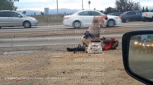 Video shot by a motorist showed a CHP officer throwing a woman to the ground, straddle her body and repeatedly punching her. (Credit: David Diaz)