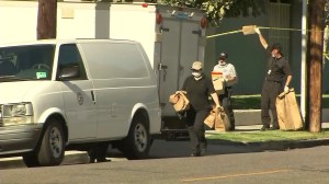 Investigators leave the scene where Xinran Ji was found dead on July 24, 2014. (Credit: KTLA)