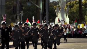 Los Angeles police officers are seen near demonstrators in Westwood on Sunday, July 13, 2014.