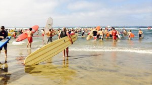 Paddle boarders enter the water for a memorial paddle out held in fallen Newport Beach lifeguard Ben Carlson's honor. (Credit: Sara Welch/KTLA)