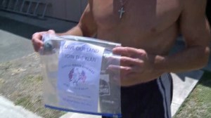 Paul Parra holds up a KKK flier on July 18, 2014. The Orange resident was one of several homes that received the fliers. (Credit: KTLA)