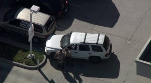 Deputies stood next to an SUV at a gas station in Moreno Valley that appeared to be a crime scene on July 22, 2014. (Credit: KTLA)