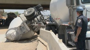 The truck, carrying sand, was launched on the K-rail and then collided with a support beam on the 215 Freeway on July 15, 2014. (Credit: KTLA)