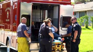Paramedics prepare to place a woman in an ambulance after she was attacked at a home in West Covina on Sunday, July 6, 2014. (Credit: Flying Lion TV)