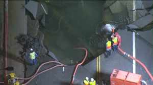 Crews gaze into massive hole created by ruptured water main on Sunset Blvd. in Westwood. (Credit: KTLA)