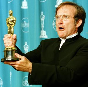Actor Robin Williams is showing holding the Oscar he won for Best Supporting Actor for his role in "Good Will Hunting" during the 70th Annual Academy Awards 23 March, 1997, in Los Angeles. (Credit: HAL GARB/AFP/Getty Images)