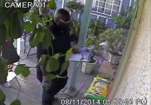 Jerry Coleman is accused of being the robber shown in this surveillance video image posing as a flower deliveryman on Aug. 11, 2014. 