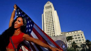 Maryel Ceballos, 29, of Los Angeles, holds up an American flag in front of City Hall. (Credit: Francine Orr/Los Angeles Times)