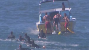 A lifeguard boat rescued a distressed swimmer and three lifeguards who were struggling at the Wedge in Newport Beach on Aug. 27, 2014. (Credit: KTLA)