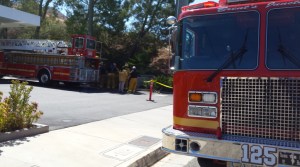 Rescue crews work to remove a person trapped under a sign at a Mobil gas station in Calabasas on Friday, Aug. 22, 2014. (Credit: KTLA)