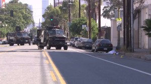 A SWAT armored truck helped save officers in a shootout on Aug. 18, 2014, police said. An alleged gunman's body lay in the street after the shooting. (Credit: KTLA)