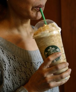 A woman takes a drink from a 26-ounce Caramel Frappuccino at a Starbucks on the Upper East Side of New York City March 11, 2013. (Credit: TIMOTHY A. CLARY/AFP/Getty Images)