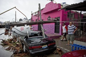 People look at the destruction caused by hurricane Odile after it knocked down trees and power lines in Cabo San Lucas, in Mexico's Baja California peninsula, on Sept. 15, 2014. (Credit: Ronaldo Schemidt/AFP/Getty Images)