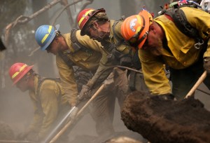 Firefighters mop up hot spots in an area burned by the King fire on Friday near Pollock Pines, Calif. The King fire is threatening more than 12,000 homes in the forested area about an hour east of Sacramento. (Credit: Justin Sullivan/Getty Images)