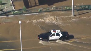 A Los Angeles Police Department car car be seen driving through a flooded street in West Hollywood after a water main break on Sept. 26, 2014. (Credit: KTLA)