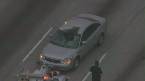 A car sustained major damage after being hit by a bouncing tire on Sept. 3, 2014. (Credit: KTLA)