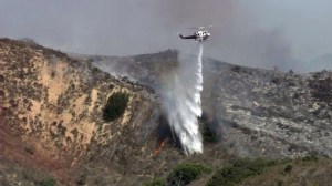 A helicopter drops water on the Foothill Fire in Ventura on Sept. 29, 2014. (Credit: KTLA)