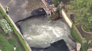 Water is seen swirling from beneath a collapsed road in Encino on Monday, Sept. 8, 2014. (Credit: KTLA)