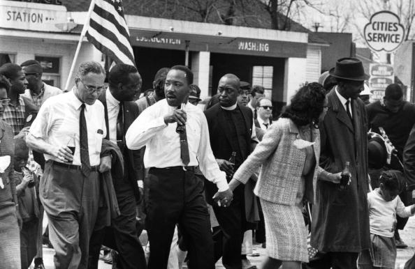 March 1965: Martin Luther King (1929 - 1968) and his wife Coretta Scott King lead a civil rights march from Selma, Alabama, to the state capital in Montgomery. On the left (holding bottle) is American diplomat Ralph Bunche (1904 - 1971). (Photo by William Lovelace/Express/Getty Images)