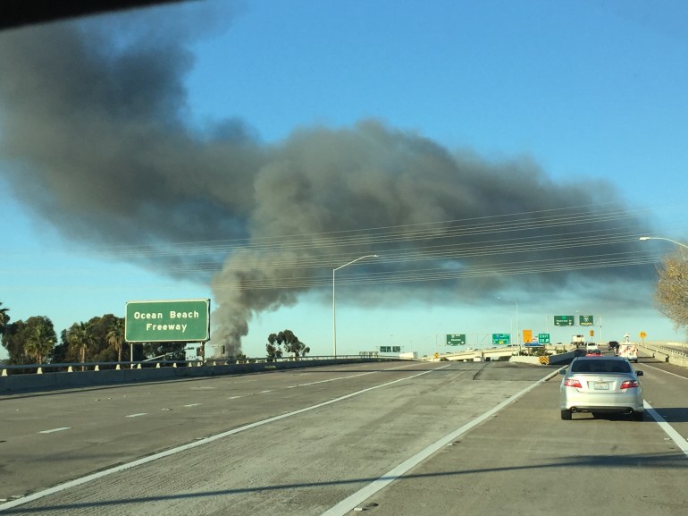 Plume of smoke in Midway District was seen for miles around.