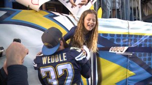 Eric Weddle helps his daughter down to the field at Qualcomm Stadium during the Chargers last home game of the 2015 season.