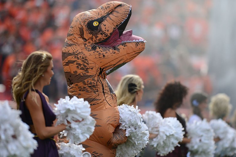 A Denver Broncos cheerleader in a dinosaur costume before the game against the San Diego Chargers at Sports Authority Field at Mile High on October 30, 2016 in Denver, Colorado. (Getty Images)