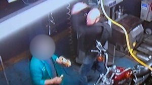 The violent attack was captured on one of the auto shop's security cameras.