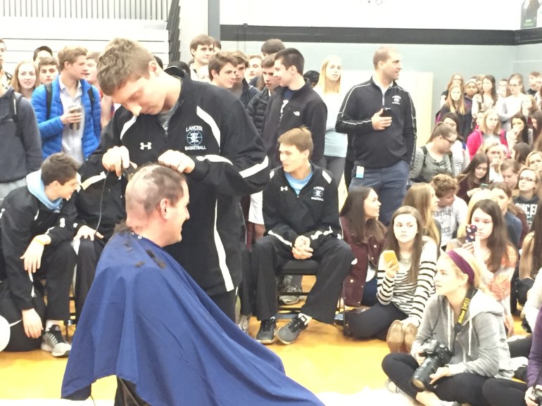 Shawnee Mission East varsity boys’ basketball Coach Shawn Hair shaved his head on Thursday to bring awareness for pediatric cancer.