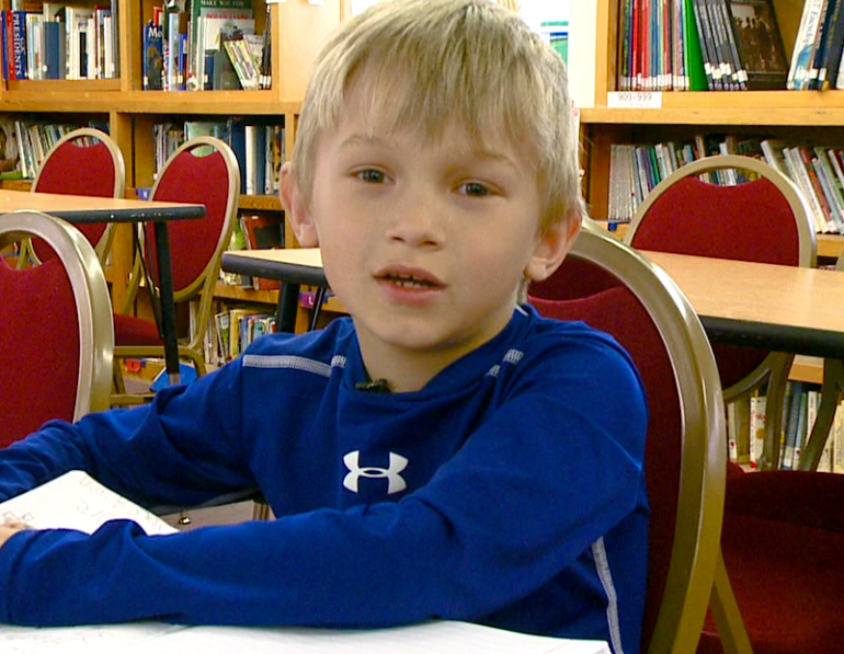 J.W., 7, brought in money and wore blue for the Lancaster family.