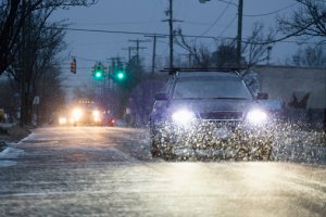 Car driving on snowy urban street at night Spaces Images