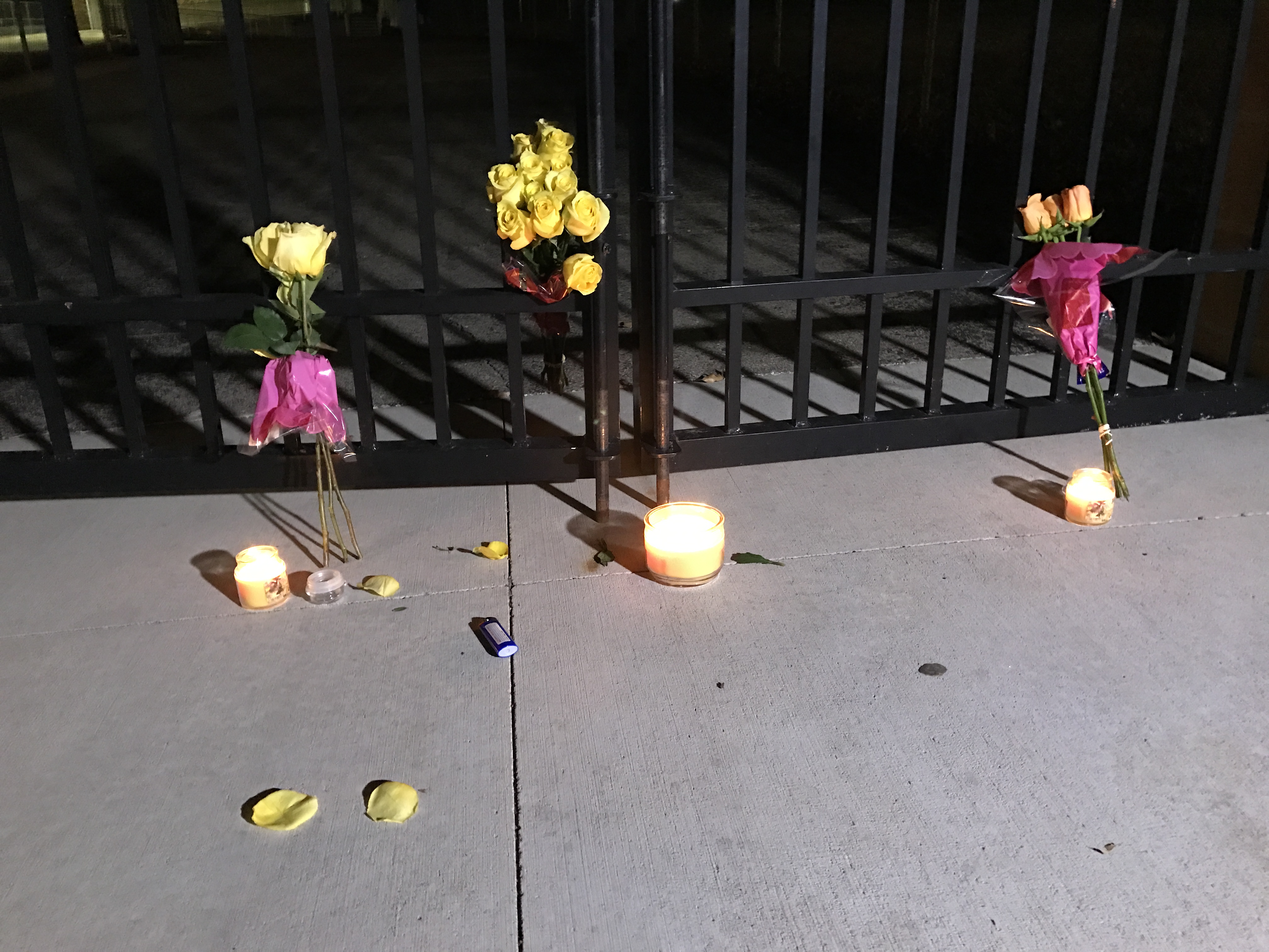 Candles and flowers are left outside Blue Valley High School Sunday.