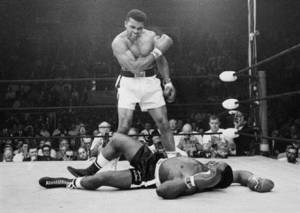In this May 25, 1965, file photo, heavyweight champion Muhammad Ali, then known as Cassius Clay, stands over challenger Sonny Liston, shouting and gesturing shortly after dropping Liston with a short hard right to the jaw, in Lewiston, Maine. Ali's body will ride in a miles-long procession spanning his life — from his boyhood home where he shadowboxed and dreamed of greatness to the boulevard that bears his name and the museum that stands as a lasting tribute to his boxing triumphs and his humanitarian causes outside the ring. Ali died last Friday at 74 after a long battle with Parkinson's disease. (AP Photo/John Rooney, File)