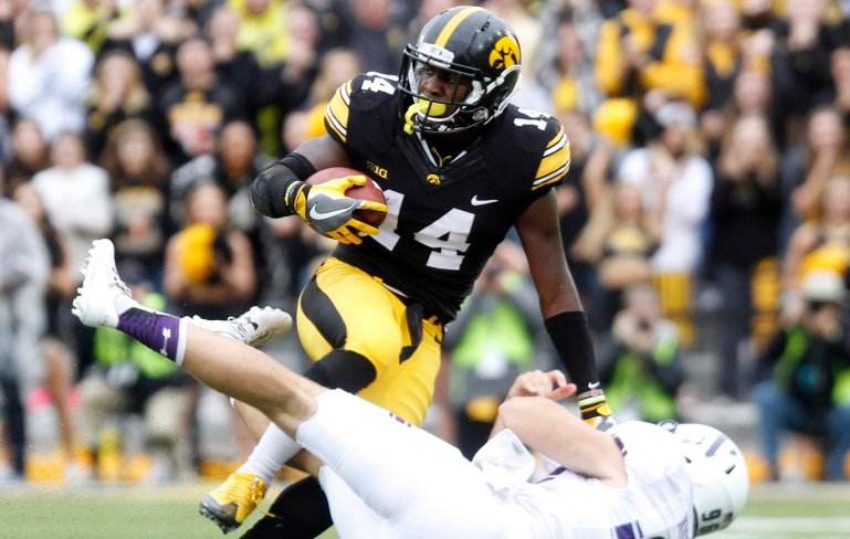 IOWA CITY, IOWA- OCTOBER 1: Defensive back Desmond King #14 of the Iowa Hawkeyes is pulled down during the second quarter by punter Hunter Niswander #96 of the Northwestern Wildcats on October 1, 2016 at Kinnick Stadium in Iowa City, Iowa. (Photo by Matthew Holst/Getty Images)