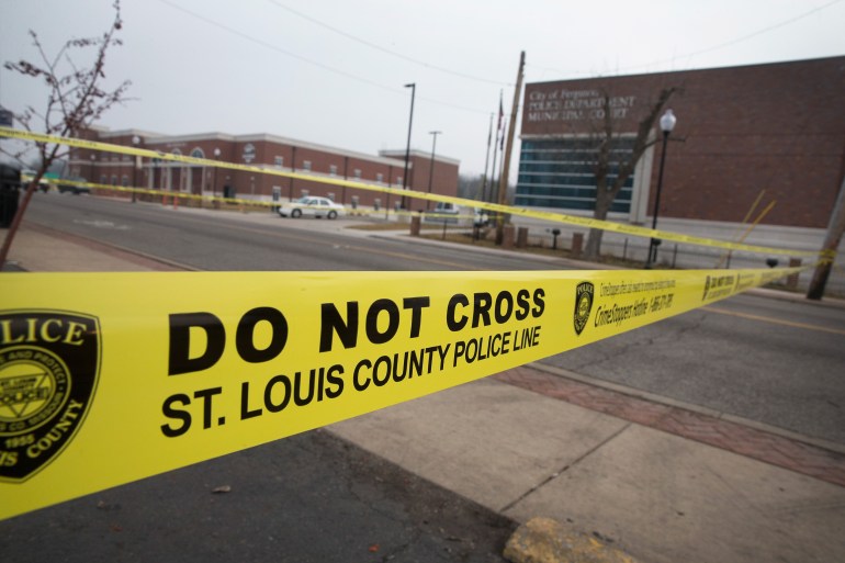  Law enforcement officials secure the crime scene and continue to search for evidence outside the police station after two officers were shot and wounded during last night's protest on March 12, 2015 in Ferguson, Missouri. Demonstrators had gathered outside the station to celebrate and protest after learning the city's police chief would be stepping down following the release of a Justice Department report that disparaged the department. Ferguson has faced many violent protests since the August shooting death of Michael Brown by a Ferguson police officer.  (Photo by Scott Olson/Getty Images)