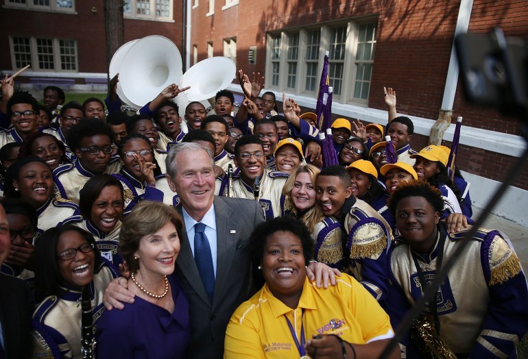 Former President George Bush and former First Lady Laura Bush take a selfie photo with Asia Muhaimin, the Warren Easton High School band director, and the rest of the marching band during a visit to the school to mark the 10th anniversary of Hurricane Katrina on August 28, 2015 in New Orleans, Louisiana. ( Joe Raedle/Getty Images)