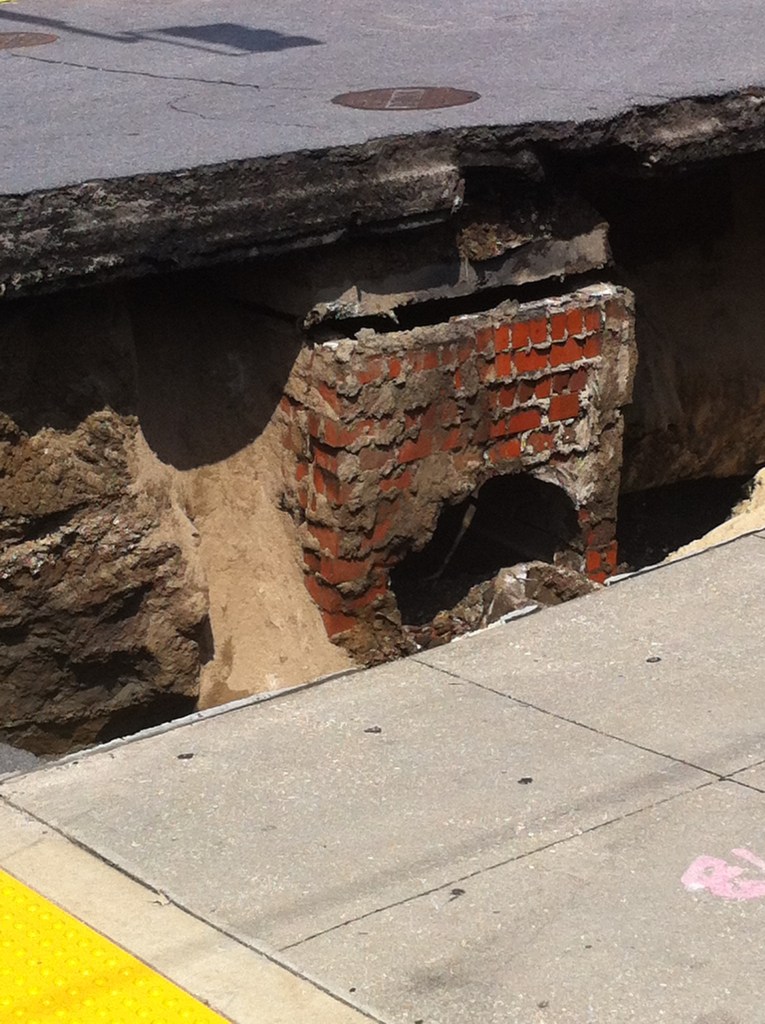 A large hole opened at the foot of Canal Street Friday, April 29, 2016. (Eugene Johnson/WGNO)