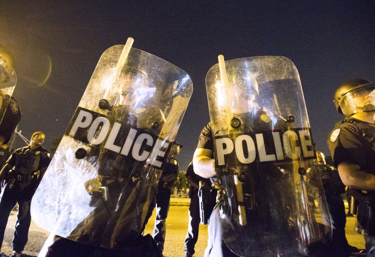 BATON ROUGE, LA -JULY 08: Protesters face off with Baton Rouge police in riot gear across the street from the police department on July 8, 2016 in Baton Rouge, Louisiana. Alton Sterling was shot by a police officer in front of the Triple S Food Mart in Baton Rouge on July 5th, leading the Department of Justice to open a civil rights investigation. (Photo by Mark Wallheiser/Getty Images)