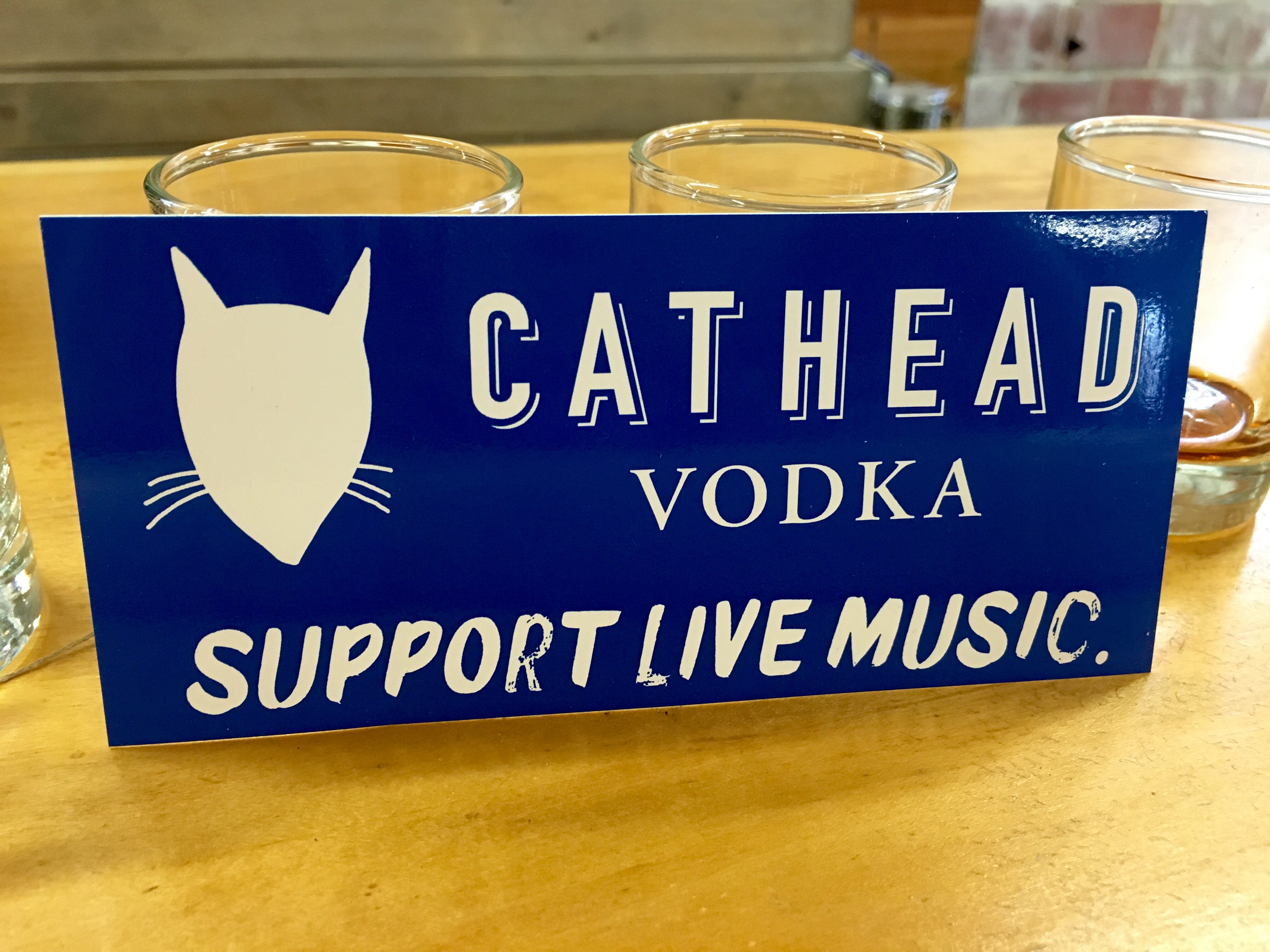 A bumper sticker declares the musical intentions of Cathead Vodka.