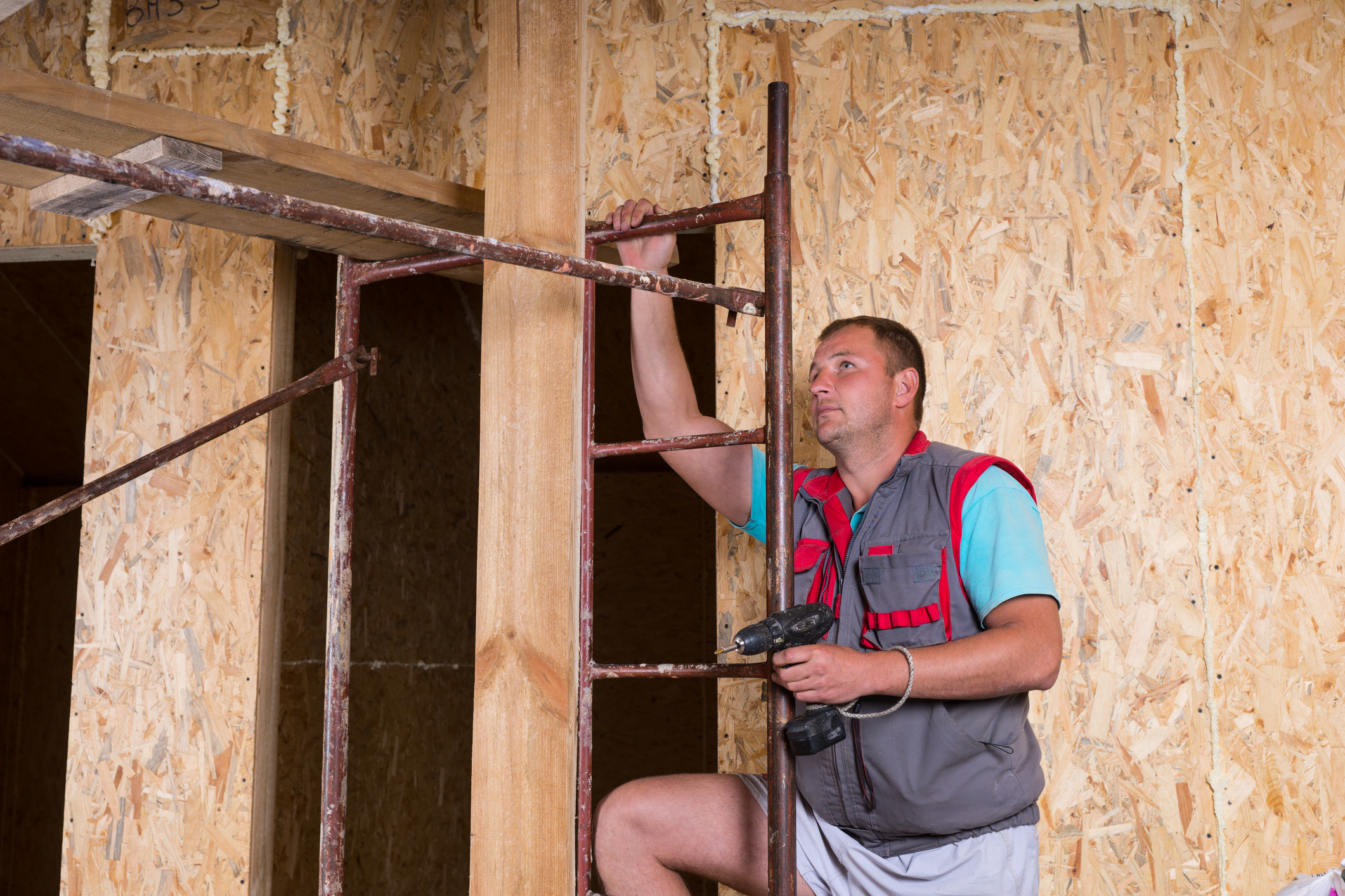 Builder with drill repairing a home.