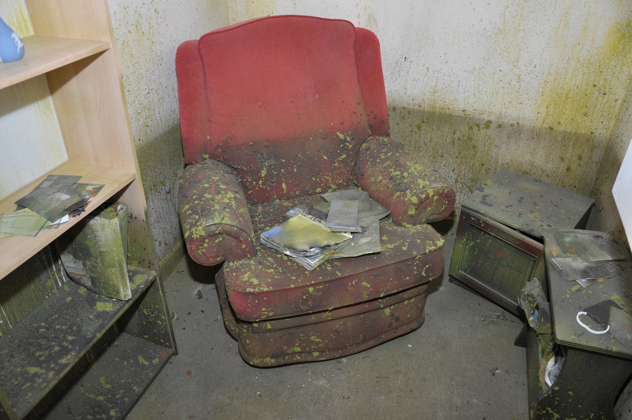 A room damaged by a flood, showing the water line and the sediment left on the furniture.