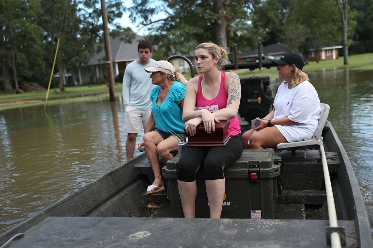BATON ROUGE, LA - AUGUST 15: Allie Amond holds a box with her father's ashes in it that she retrieved from her flooded home on August 15, 2016 in Baton Rouge, Louisiana. Record-breaking rains pelted Louisiana over the weekend leaving the city with historic levels of flooding that have caused at least seven deaths and damaged thousands of homes. (Photo by Joe Raedle/Getty Images)