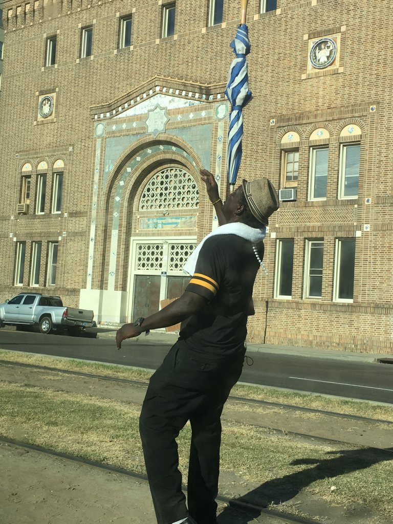 Homeless man stops traffic with umbrella tricks