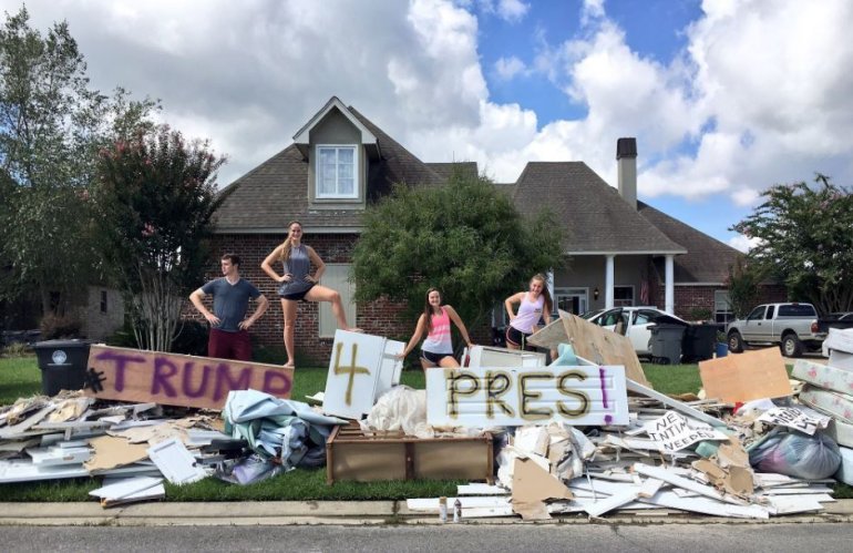 Donald Trump fans show their support outside a flood-ravaged home in the Baton Rouge area.