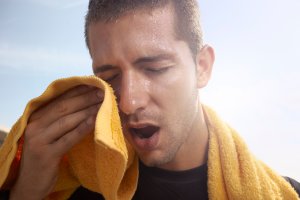 Man wiping sweat off his skin. (Thinkstock)