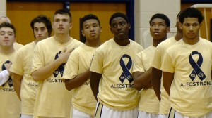 Wearing gold "Alecstrong" T-Shirts, Decatur Central players stand during a moment of Silence Saturday for Alec Dye.